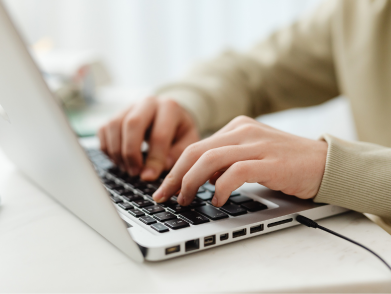 A person actively engaged in typing on a laptop keyboard